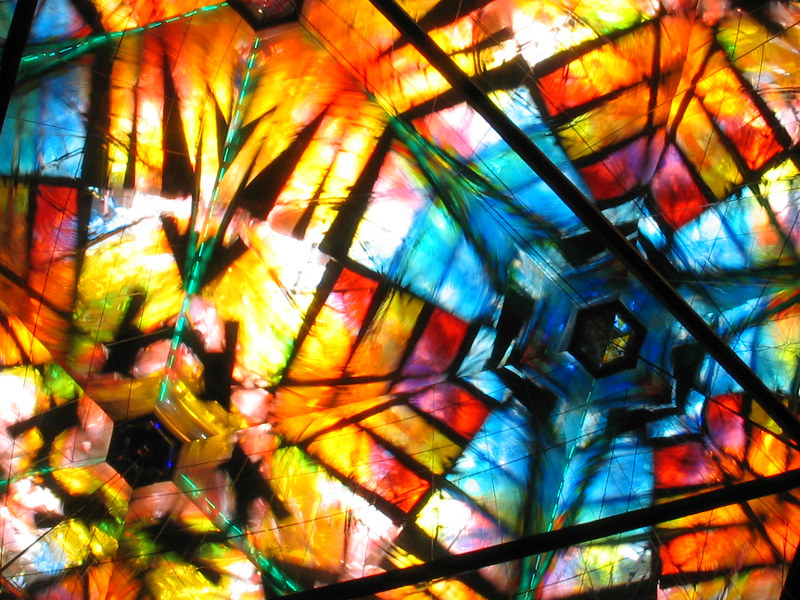 A multi-colored refraction of a kaleidoscope with light shining through.