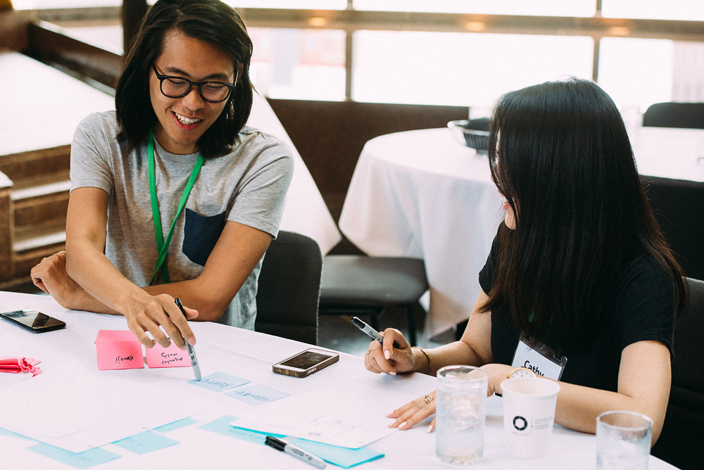 two participants at a conference laughing and talking together